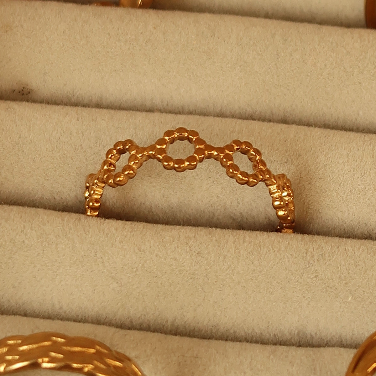 Linked ring in gold on a velvet tray #Color_Gold